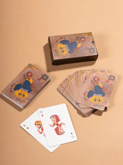 A minimalist flat lay of Namostutay playing cards on a neutral background. This simple setup allows the intricate, artistic illustrations on the cards to stand out.