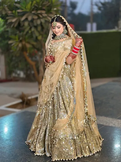 A full view of the gold sequin lehenga, showing its magnificent flare and how the light plays off the thousands of sequins. This is a true statement piece available for rent.