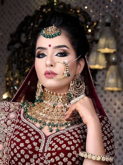 A model with dramatic makeup wearing a heavy choker with emerald green beads. This look is perfect for bridal photoshoots where you want a bold and impactful style.