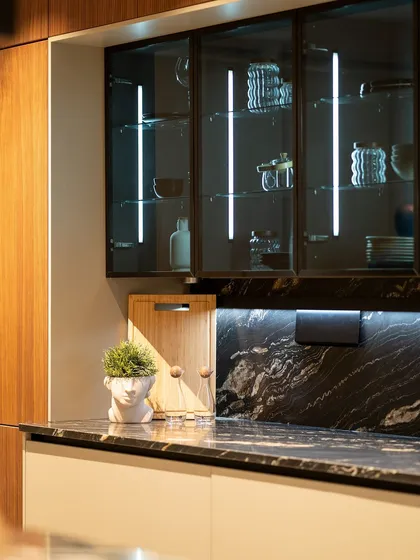 The little details matter. This close-up shows our illuminated glass cabinets and a sleek black marble countertop, creating a sophisticated look.