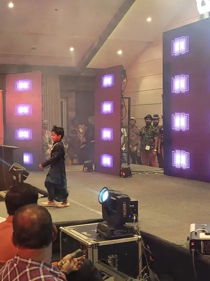 A young performer confidently walking the LED runway at a fashion show event I managed. The lighting and stage effects are programmed to enhance the performance and captivate the audience.