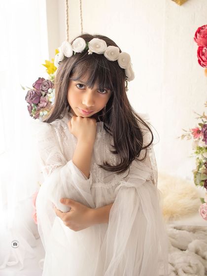 A beautiful, intimate portrait by the floral swing. The soft light and her thoughtful expression create a captivating image.