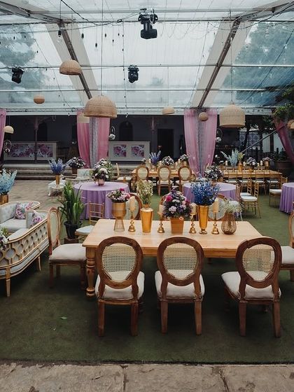 An overview of the reception setup under the clear-top tent, showing a mix of round and long tables.