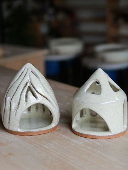 These hand carved luminaries, shaped like little houses, show the delicate and imaginative work of our professional students, designed to cast a warm, patterned glow.