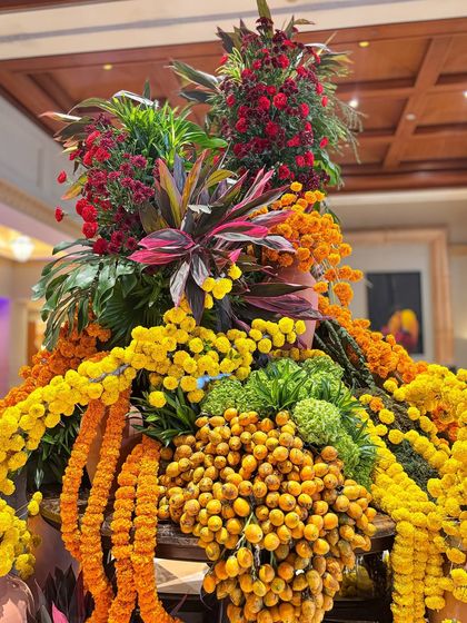 A close-up showing the rich variety of flowers and colors in the lobby installation. The deep reds, bright yellows, and fresh greens come together in a harmonious and festive display.