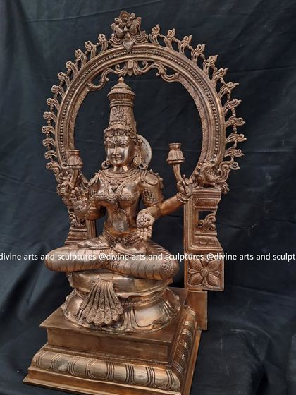 A finished bronze sculpture of Mahalakshmi seated within an ornate archway. This piece embodies spiritual wealth, including noble values and the power of the mind.