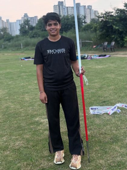 A female athlete poses with her javelin. Confidence is a key part of performance, and we build it through rigorous preparation.