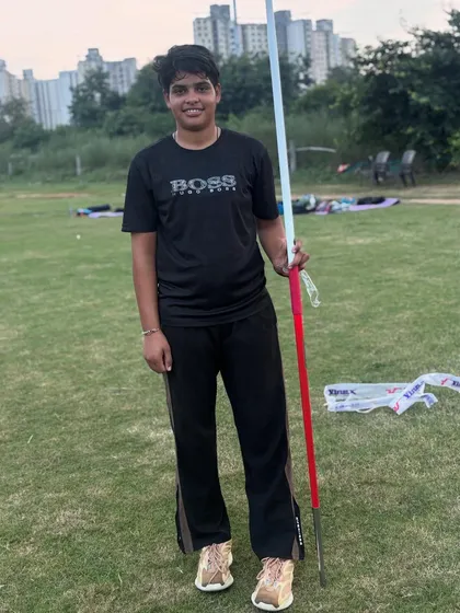 A female athlete poses with her javelin. Confidence is a key part of performance, and we build it through rigorous preparation.