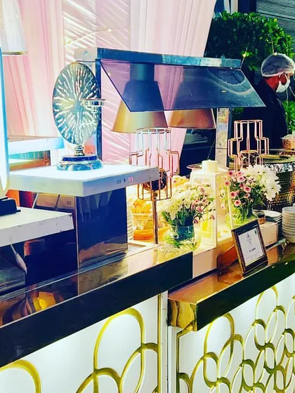Another angle of a stylish catering presentation, highlighting the use of modern lamps and reflective surfaces. I design these setups to be a focal point of your event, not just a place to serve food.