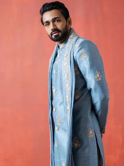 Another view of the light blue sherwani, highlighting the detailed embroidery on the stole and cuffs.