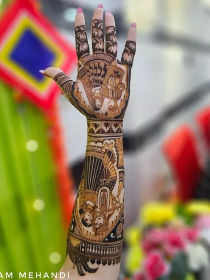 A close-up of the full arm design, showing the beautiful bokeh background that highlights the mehndi. The design features a Radha-Krishna portrait and a doli scene.