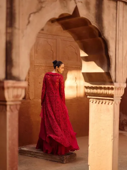 A dramatic shot from the Awigna campaign, featuring a stunning red layered outfit. The color is powerful and timeless.