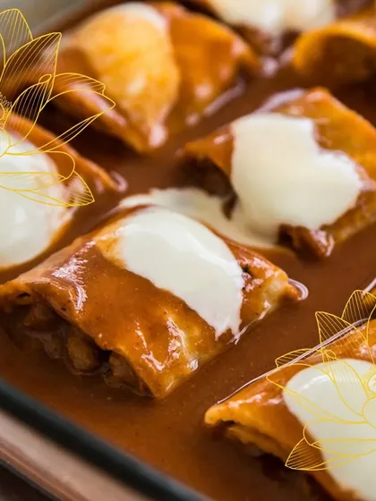 A comforting and rich dish, possibly a vegetable enchilada or baked pasta, generously topped with sauce and cheese. This showcases our expertise in hearty global vegetarian cuisine.