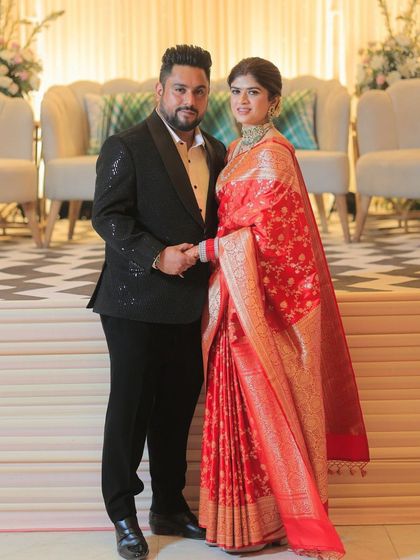Another shot of the couple, showcasing the bride's radiant makeup and the intricate details of her red saree.