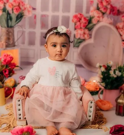 Sitting like a little queen on her throne, surrounded by flowers. This setup is perfect for celebrating an 8-month milestone.