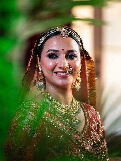 A candid shot through the leaves, creating a lovely, natural frame for this happy bride.