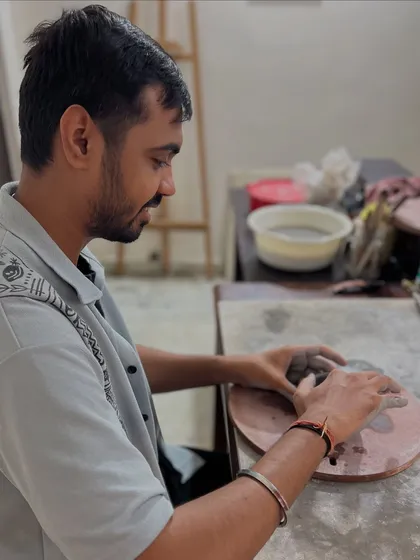 A quiet moment of focus during an anniversary clay date. The studio provides a peaceful backdrop for couples to slow down and enjoy the creative process together.