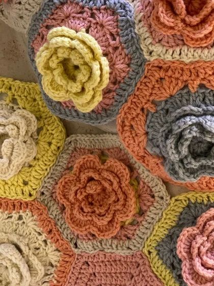 A close-up of hand-crocheted hexagonal flowers from the 'Hope You're Well' installation. These tactile details, made with soft yarns, were central to creating a space focused on wellbeing and empathy.