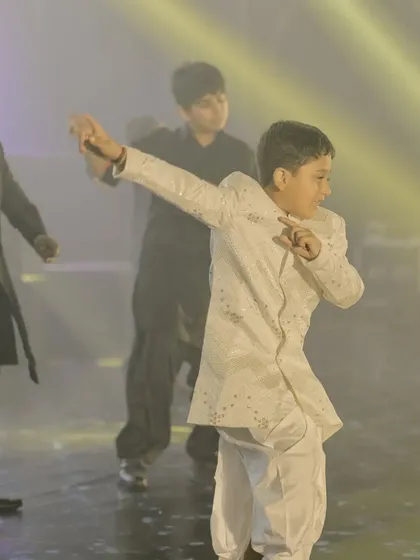 This young performer is hitting a cool move during a sangeet performance. Our choreography for kids focuses on simple steps and lots of fun, so they feel comfortable and confident on stage.