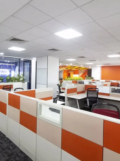 An open-plan workstation area at Scientific Games designed for productivity. We used a combination of neutral desks and colorful partition panels, complemented by motivational wall graphics like "Work Hard Stay Humble," to create a balanced and focused environment.