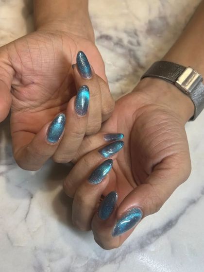 A stunning teal cat-eye effect on almond-shaped nails. The color is rich and vibrant, and the magnetic shimmer gives it a beautiful, liquid-like appearance.