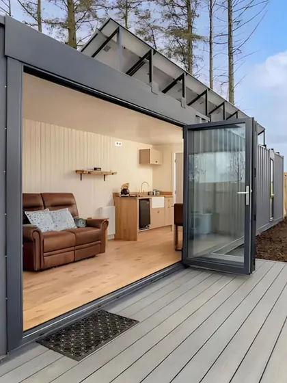 A view of our solar-powered container home, featuring a large deck and bi-fold doors that open up the living space. This design is perfect for off-grid living without sacrificing modern comforts.