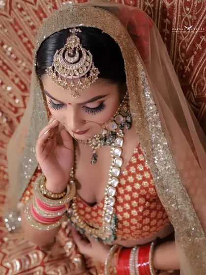 An overhead shot focusing on the bride's maang tikka and the top-down view of her lehenga.