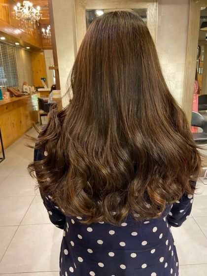 A light brown and golden balayage that looks like it was naturally lightened by the sun. The soft waves really show off the color dimension.