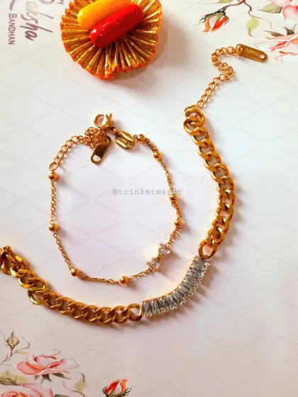 For a modern and chic couple, this Bhai Bhabhi set is perfect. It features a stylish gold-plated chain bracelet for bhai and a matching delicate one for bhabhi, both with sparkling crystal details.