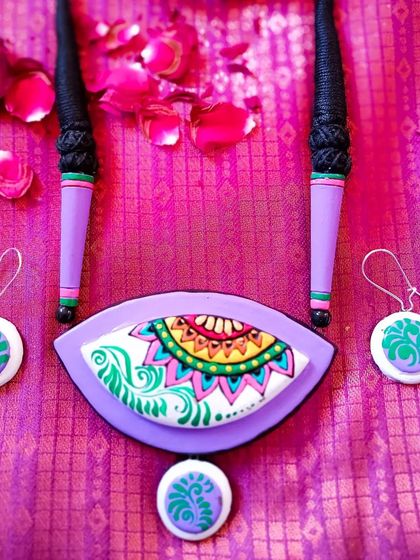 A close-up of the eye-shaped pendant in a lovely lavender and green color scheme.