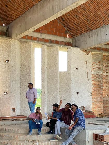 Our team on a site visit, studying the vaulted brick ceiling and natural light shafts in a building under construction.