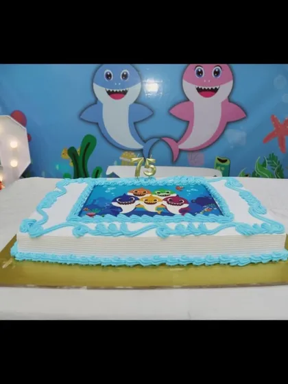 Themed cakes are a must. This Baby Shark cake features an edible image of the beloved characters, perfectly matching the party's underwater theme.