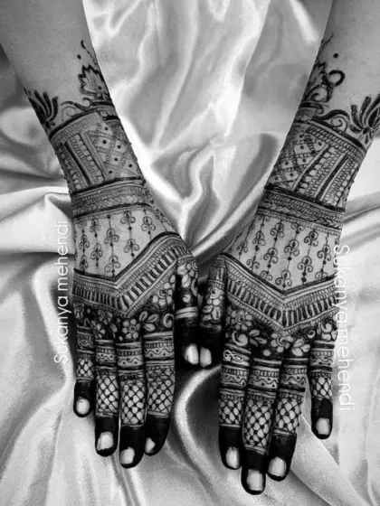 A black and white shot that emphasizes the contrast and detail of this geometric bridal design, showcasing the fine lines and filled-in fingertips.