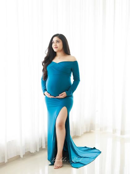 A full-length view of the classic off-shoulder teal gown, showing how its elegant train pools at the floor for a touch of drama.