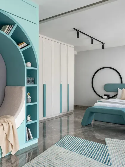 This shot highlights the circular reading nook and the custom bed in the kids' room. The design uses geometric shapes and a cool color palette to create a modern and playful environment.
