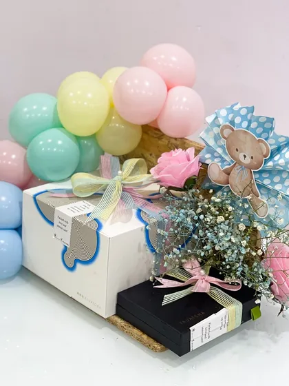 The "Mom-to-be" food hamper also includes other beautifully wrapped gifts, flowers, and balloons, making it a complete and festive baby shower present.