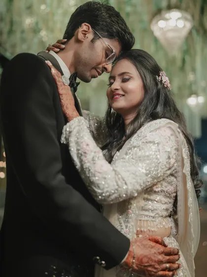 A classic, romantic portrait of the couple at their reception. The groom's embrace and their gentle expressions create a feeling of warmth and intimacy.