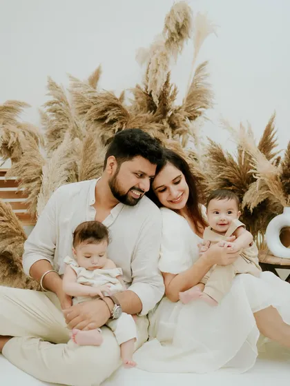 A beautiful family of four. This portrait captures the love and joy of life with twins, set against a stylish and modern pampas grass backdrop.