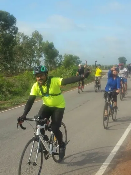 The group riding in formation on a paved road leading to a trail. It's smiles and waves all around.