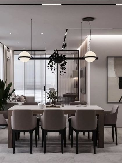 A modern dining setup featuring a dark wood table and grey upholstered chairs. The hanging plant and spherical pendant lights add a contemporary and stylish touch.