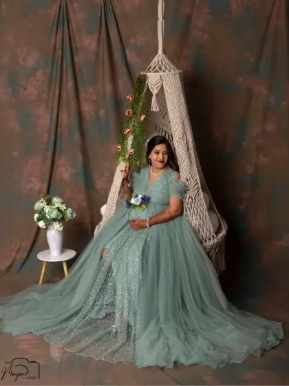 A portrait of pure grace on our macrame swing. The flowing sea-green gown and soft lighting create a magical and serene atmosphere for this solo maternity shot.