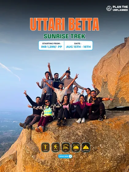 A group of trekkers celebrates at the top of Uttari Betta during a sunrise trek. Join us for an early morning adventure to witness a spectacular sunrise.