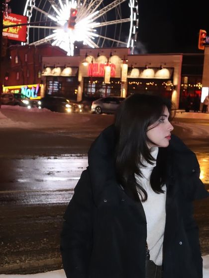 A close-up profile shot against the bright lights of Clifton Hill.