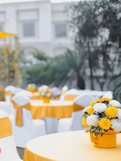 A view of the guest seating area at the Haldi, with tables and chairs decorated in a cheerful yellow and white theme.