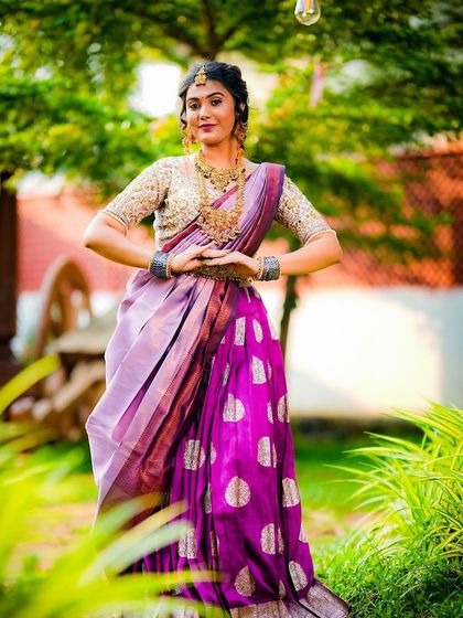 A full-length shot of the lavender and purple half saree, showing the big buttas on the skirt and the rich texture of the fabric. This is a great example of a semi-bridal or occasion wear outfit.