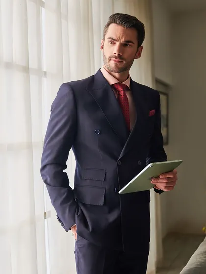 Holding a tablet, this image places the double-breasted suit in a modern business context. It's a timeless style that remains relevant and powerful today.