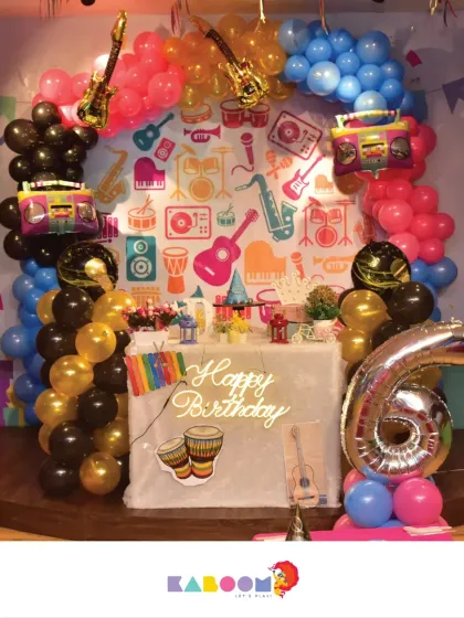 Let's rock and roll! This music-themed party is perfect for a little rockstar, with a backdrop of instruments, guitar-shaped balloons, and a neon "Happy Birthday" sign.