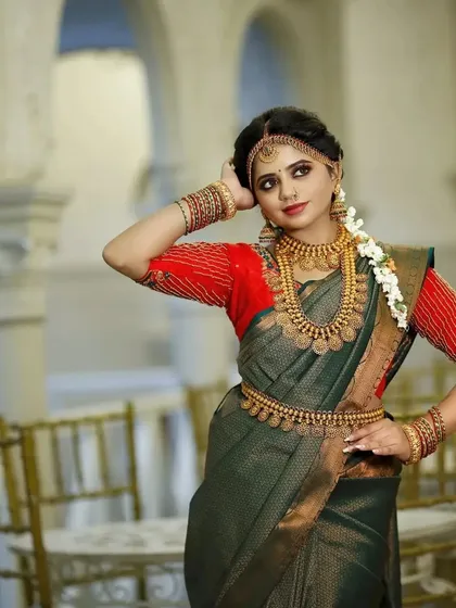 This model showcases a traditional look with a kasu malai set, complete with a matching vaddanam and jhumkas, perfect for a classic muhurtham.