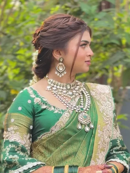 A side profile of the bride, showing the beautiful braided hairstyle and the delicate gajra.