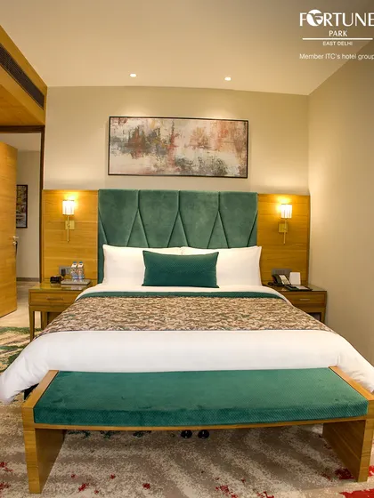 Our signature emerald green room offers a touch of opulence. The room features a king-sized bed, a velvet-upholstered bench, and coordinated decor for a cohesive, elegant feel.